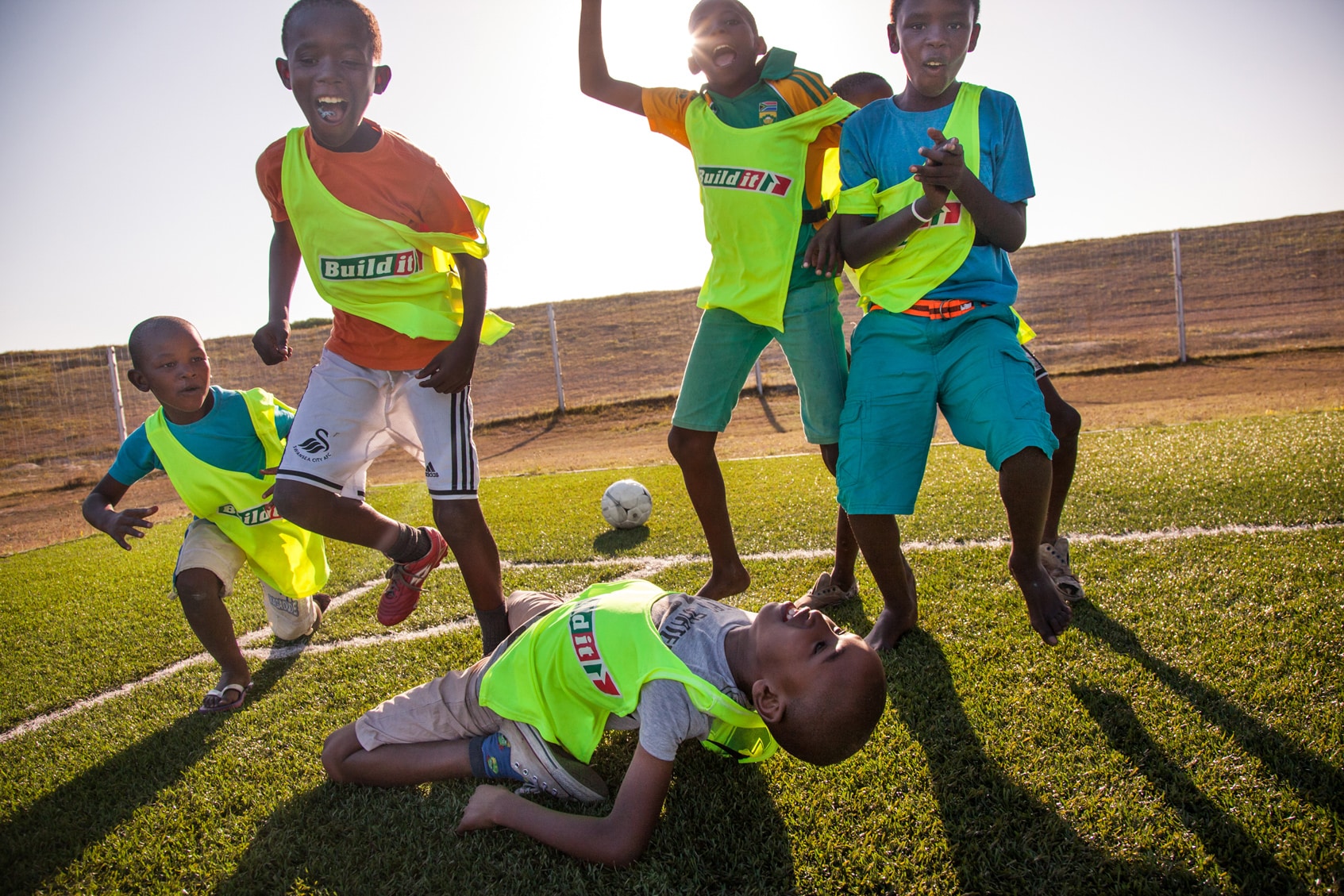 A group of children cheering on a soccer field.